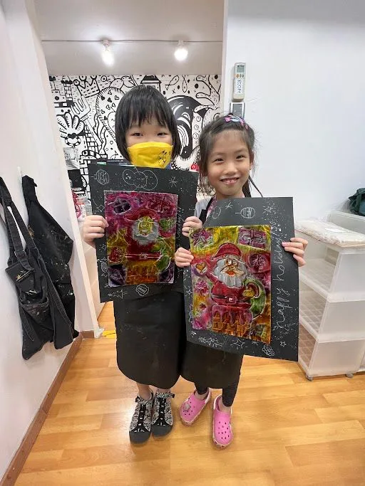 Children showing colourful festive embossed artwork.