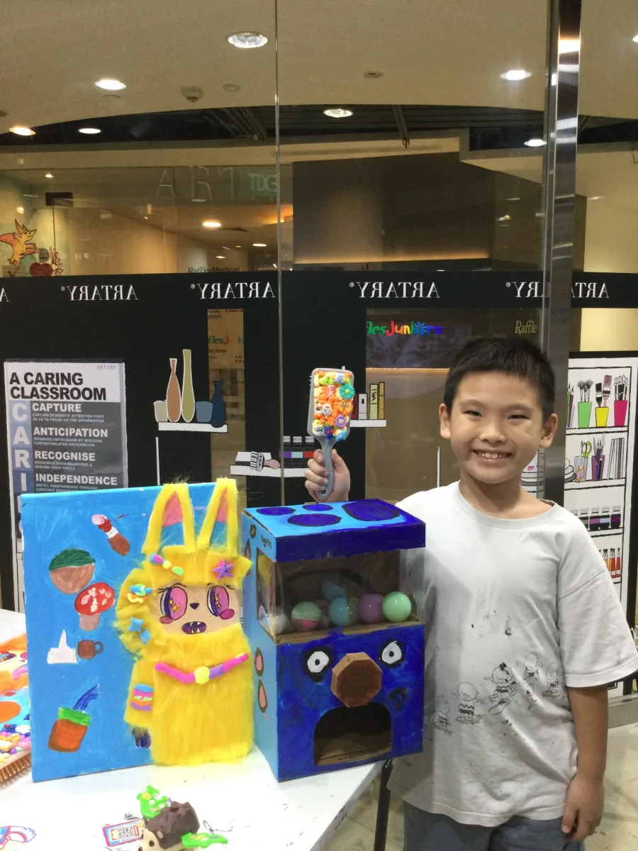 Child showing a furry portrait, capsule machine and decorated handheld piece.
